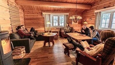 Gruppe koser seg i stua i Haugbu, utleiehytte ved Venabu Fjellhotell