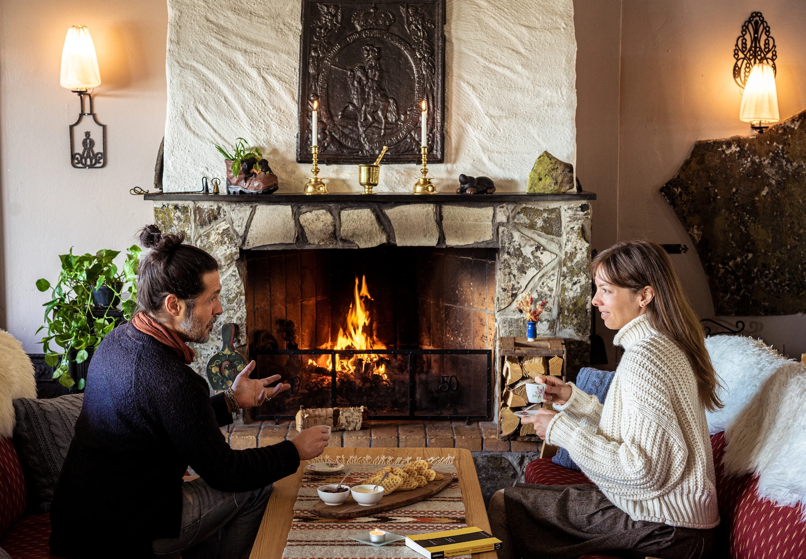 Two people chat by the fire Venabu Fjellhotell
