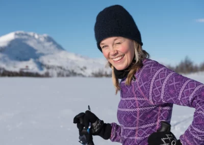 Female cross country skier smiles towards the camera