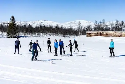 Group of cross country skiers play football in a lesson