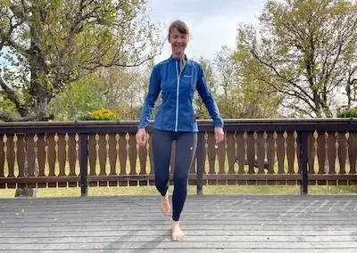 Woman balances on one leg, eyes closed