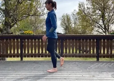 Woman balances on one leg.