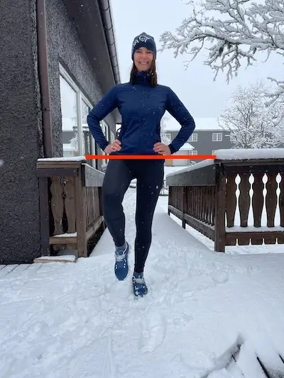 Woman balances on one leg against a snowy background