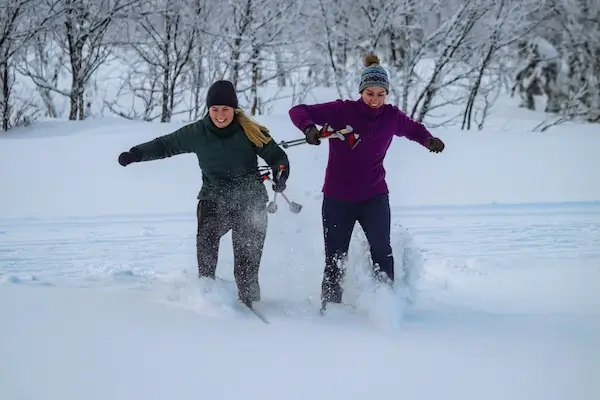 two_women_running_in_snow. Venabu